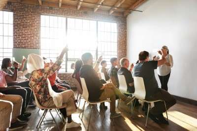 People raising their hands in a seminar