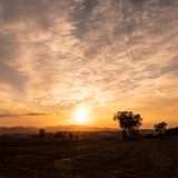 A sunrise with mountains and trees